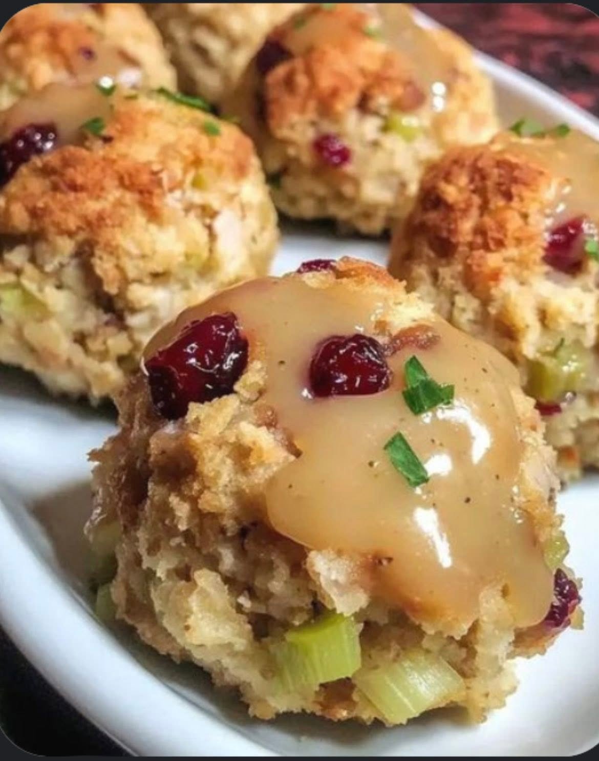 Catori Artisan Stuffing Bites With Gravy And Cranberries - CATORI Artisan Close-up of crumbly muffins studded with dried cranberries and celery, with a light caramel glaze on top.